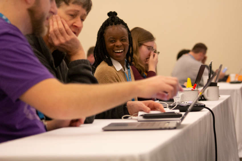 African American woman laughing among other attendees at a WCUS 2019 workshop