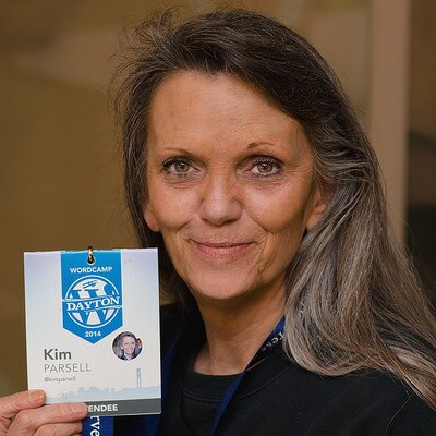Kim Parsell holding her badge from WordCamp Dayton 2014